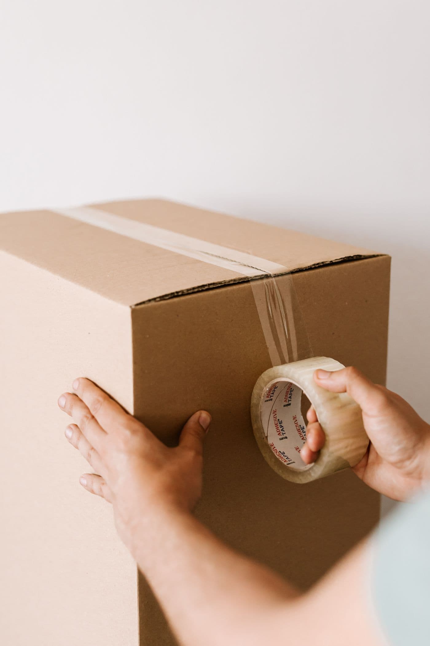 段ボールに荷物を梱包する手元
